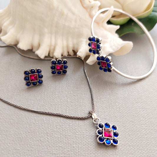 Rosy Sapphire Ensemble: Pink and Blue Stone Pendant Earring and Bracelet Set in Silver Tone